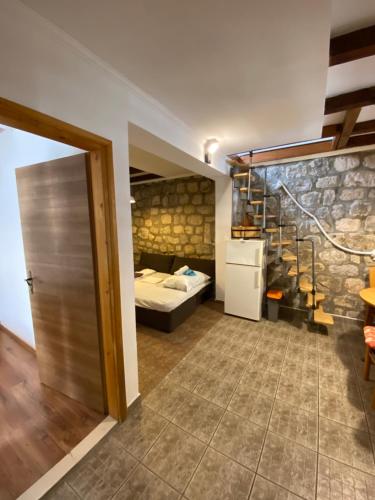 a room with a bed and a room with a refrigerator at Apartments RGETO in Ston