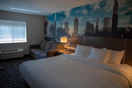 a hotel room with a bed and a couch at Clarion Pointe Indianapolis Airport in Plainfield