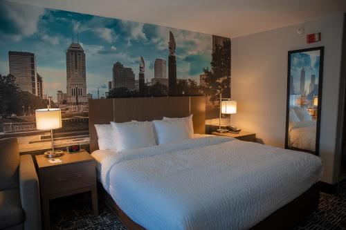 a hotel room with a bed with a view of a city at Clarion Pointe Indianapolis Airport in Plainfield