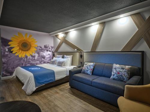 um quarto com uma cama e um sofá em Hôtel Universel, Centre de congrès Rivière-du-Loup em Rivière-du-Loup