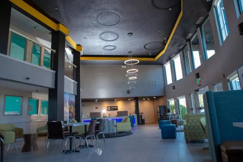 a large room with tables and chairs and windows at Clarion Pointe Indianapolis Airport in Plainfield