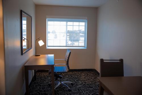 an office with a desk and a chair and a window at Clarion Pointe Indianapolis Airport in Plainfield