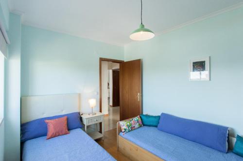 uma sala de estar com um sofá azul e uma mesa em Vista Rio em Lisboa