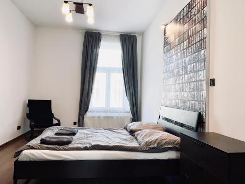 um quarto com uma cama grande e uma janela em Main Square Apartment em Cracóvia