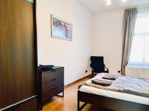 um quarto com uma cama, uma cómoda e uma janela em Main Square Apartment em Cracóvia