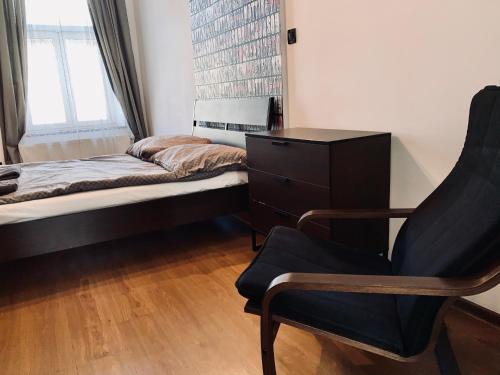 a bedroom with a bed and a chair and a dresser at Main Square Apartment in Krakow