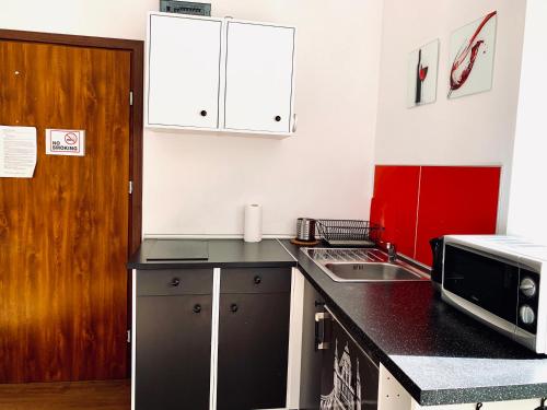 a kitchen with a black counter top and a microwave at Main Square Apartment in Krakow