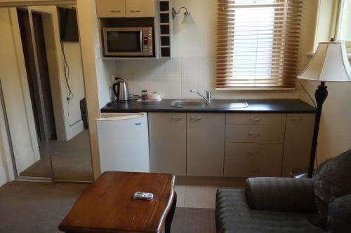 a small kitchen with a sink and a table at Manor Views NZ in Huntly