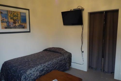 a bedroom with a bed and a television on the wall at Manor Views NZ in Huntly