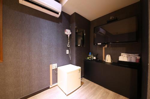 Il comprend une cuisine équipée d'un réfrigérateur blanc et d'un ventilateur. dans l'établissement Vitamin Hotel, à Busan