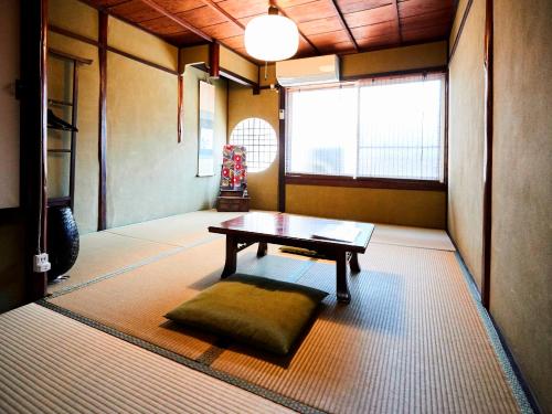 京都的住宿－和樂安旅館，一间房间,地板上配有一张桌子和一个枕头