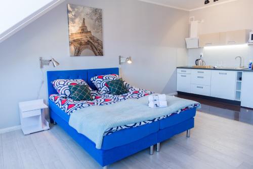 Ce lit bleu se trouve dans un dortoir doté d'une cuisine. dans l'établissement Apartments Wyszyńskiego, à Szczecin