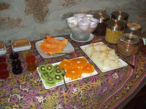 a table with plates of fruits and vegetables on it at A Flor Da Rosa in Crato