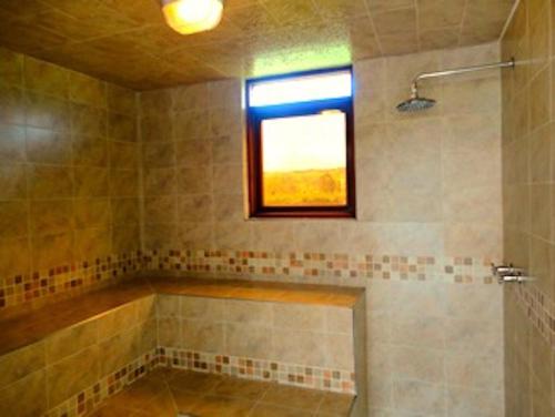 bagno con vasca e finestra di Hotel Casa de los Fundadores a Villa de Leyva