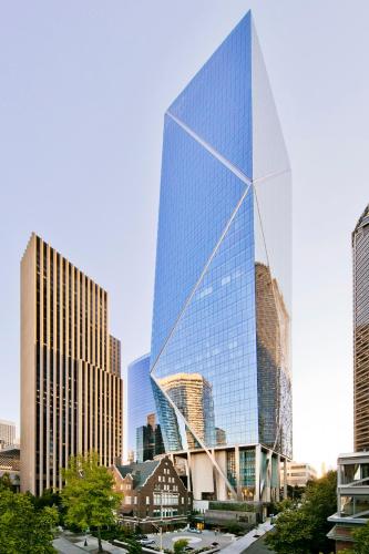 a tall glass building in a city with tall buildings at Lotte Hotel Seattle in Seattle