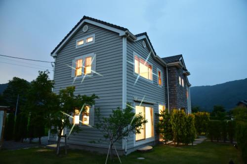 a house with its lights on in the yard at Kawaguchiko Cottage Minami in Fujikawaguchiko