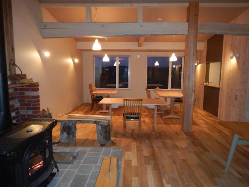 a living room with a table and a fireplace at Meiji no Okano Yado in Biei