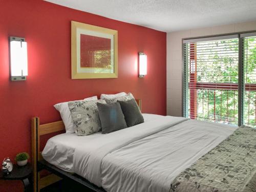 Dormitorio rojo con cama y ventana en Gatlinburg View Lodge en Gatlinburg