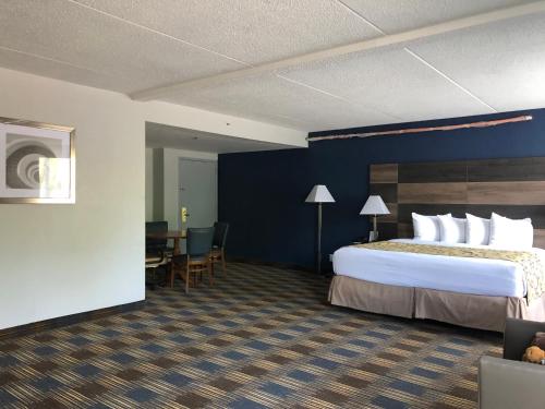 a hotel room with a bed and a desk at Baymont by Wyndham - Chicago - Addison - O'Hare in Addison