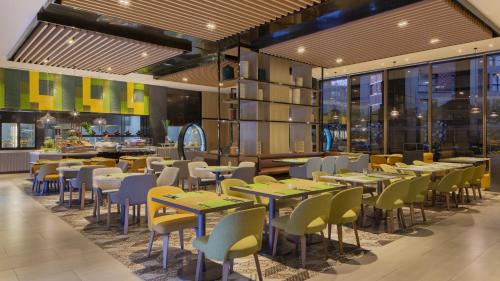 a restaurant with tables and chairs and a bar at Holiday Inn & Suites Tianjin Downtown by IHG in Tianjin