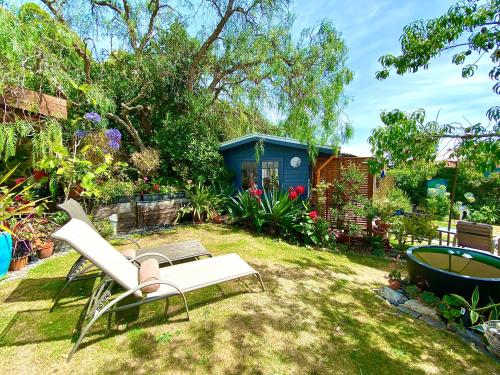 a garden with a chair and a tub in the grass at Ah House City B&B Nelson in Nelson