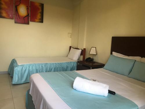 a hotel room with two beds with a towel on them at Hotel Viru Viru II in Santa Cruz de la Sierra