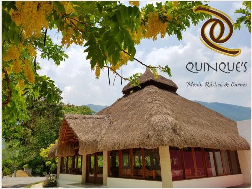 a building with a thatched roof with a sign at HI Huasteca Inn Hotel in Matlapa