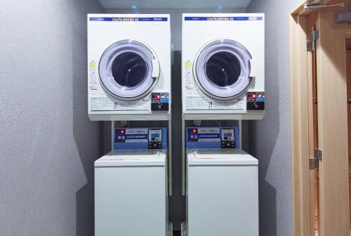 three washer and dryer machines in a room at hotel MONday Kyoto Karasuma Nijo in Kyoto