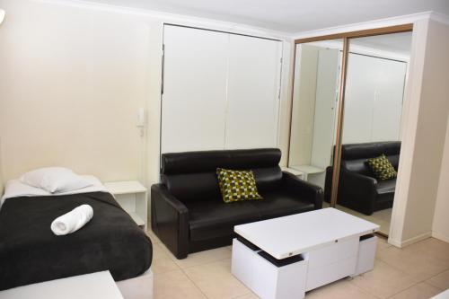 a living room with a couch and a chair at Accommodation Sydney - Hyde Park Plaza 38 College St Sydney in Sydney