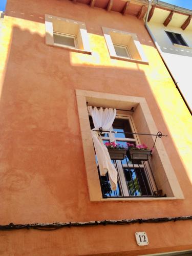 a building with a balcony with a curtain and a window at Casa Baldovinos in Palma de Mallorca