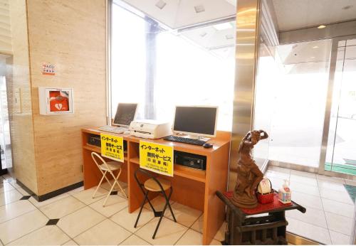 an office with a desk with a computer on it at ホテル大藏 in Kanoya
