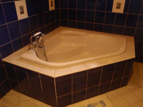 a bath tub in a bathroom with blue tiles at Las Flores Beachside Hotel in Catmon