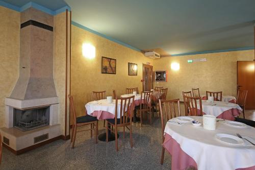 a restaurant with tables and chairs and a fireplace at Hotel Residence Ducale in Porto Mantovano