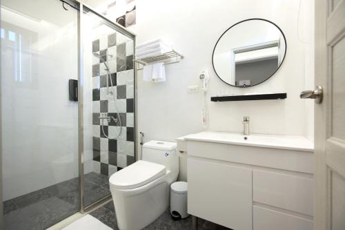 a bathroom with a toilet and a sink and a mirror at Manting Homestay in Hualien City