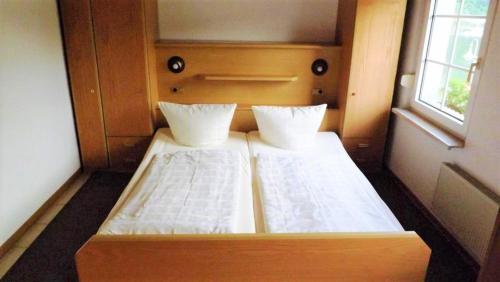 a large bed in a small room with a window at Mosel Panorama in Zell an der Mosel