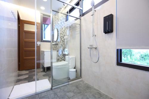 a bathroom with a toilet and a glass shower at Manting Homestay in Hualien City