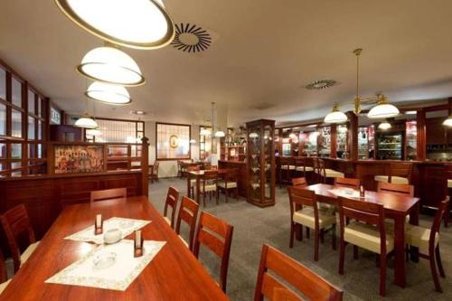 a dining room with wooden tables and chairs in a restaurant at HOTEL SVRATKA in Svratka