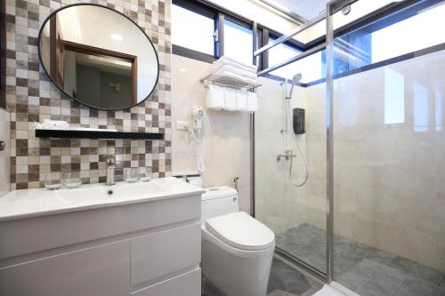 a bathroom with a toilet and a sink and a mirror at Manting Homestay in Hualien City