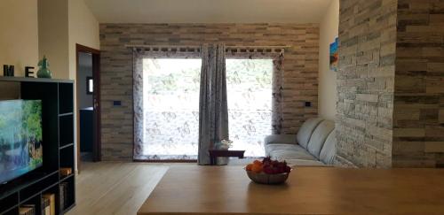 a living room with a couch and a large window at Appartamento Alissya in Tortolì