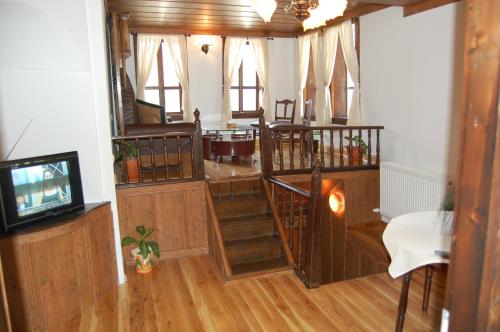 a living room with wooden floors and a tv at Kazasovata Guest House in Tryavna