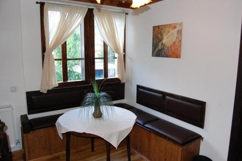 a living room with a table and a couch and a window at Kazasovata Guest House in Tryavna