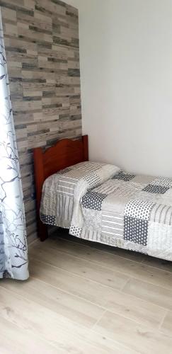 a bedroom with two beds and a wooden wall at Appartamento Alissya in Tortolì