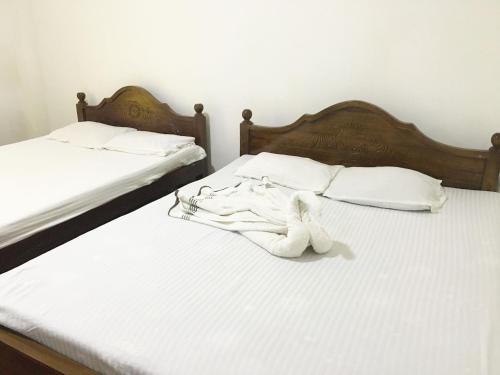 twee bedden met een knuffeldier erop bij Shiny Villa in Nuwara Eliya