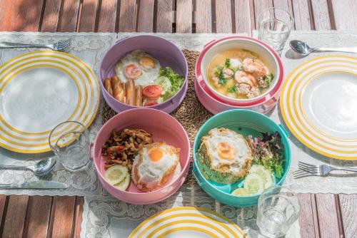 Cuatro tazones de comida en una mesa con platos. en Villa Pitak Private Pool Villa Khaoyai, en Ban Khanong Phra Nua