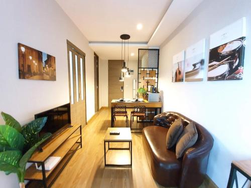a living room with a couch and a table at Modern loft room& Rooftop pool at Nimman 603NM in Chiang Mai
