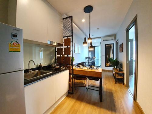 a kitchen with a sink and a table in it at Modern loft room& Rooftop pool at Nimman 603NM in Chiang Mai