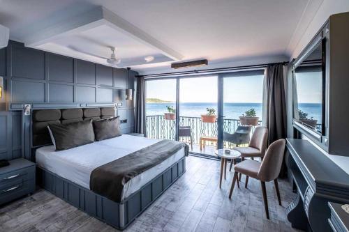 a bedroom with a bed and a view of the ocean at Assos Kervansaray Hotel - Special Category in Behramkale