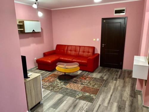 a living room with a red couch and a table at Modena rooms center of Stara Zagora in Stara Zagora