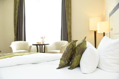 a bedroom with a bed with white pillows and a window at Kleiner Rosengarten in Mannheim
