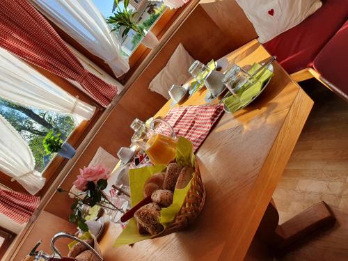 un tavolo in legno con un cesto di cibo sopra di Pension Maria a Antdorf